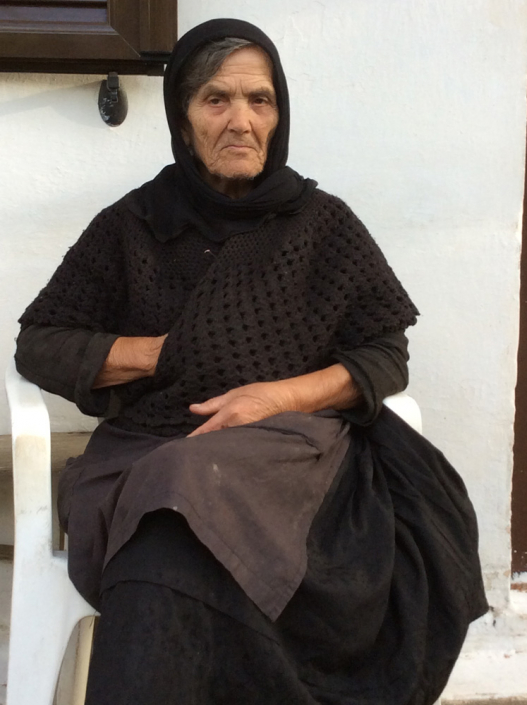 Calliope wearing typical shawl, long handmade dress, apron & headscarf. Clliope wears black in mourning for her daughter.