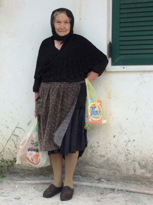 Local woman wearing skirt traditionally pulled up at sides and back into a bustle.