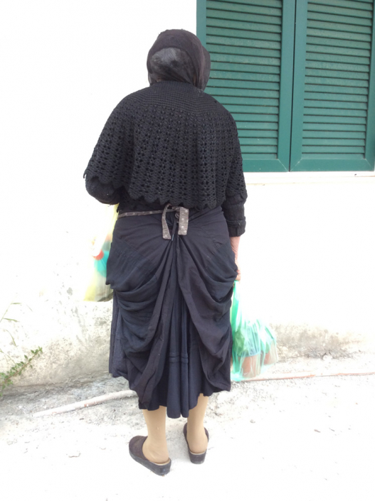 Local woman wearing skirt traditionally pulled up at sides and back into a bustle.