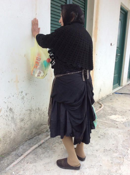 Local woman wearing skirt traditionally pulled up at sides and back into a bustle.
